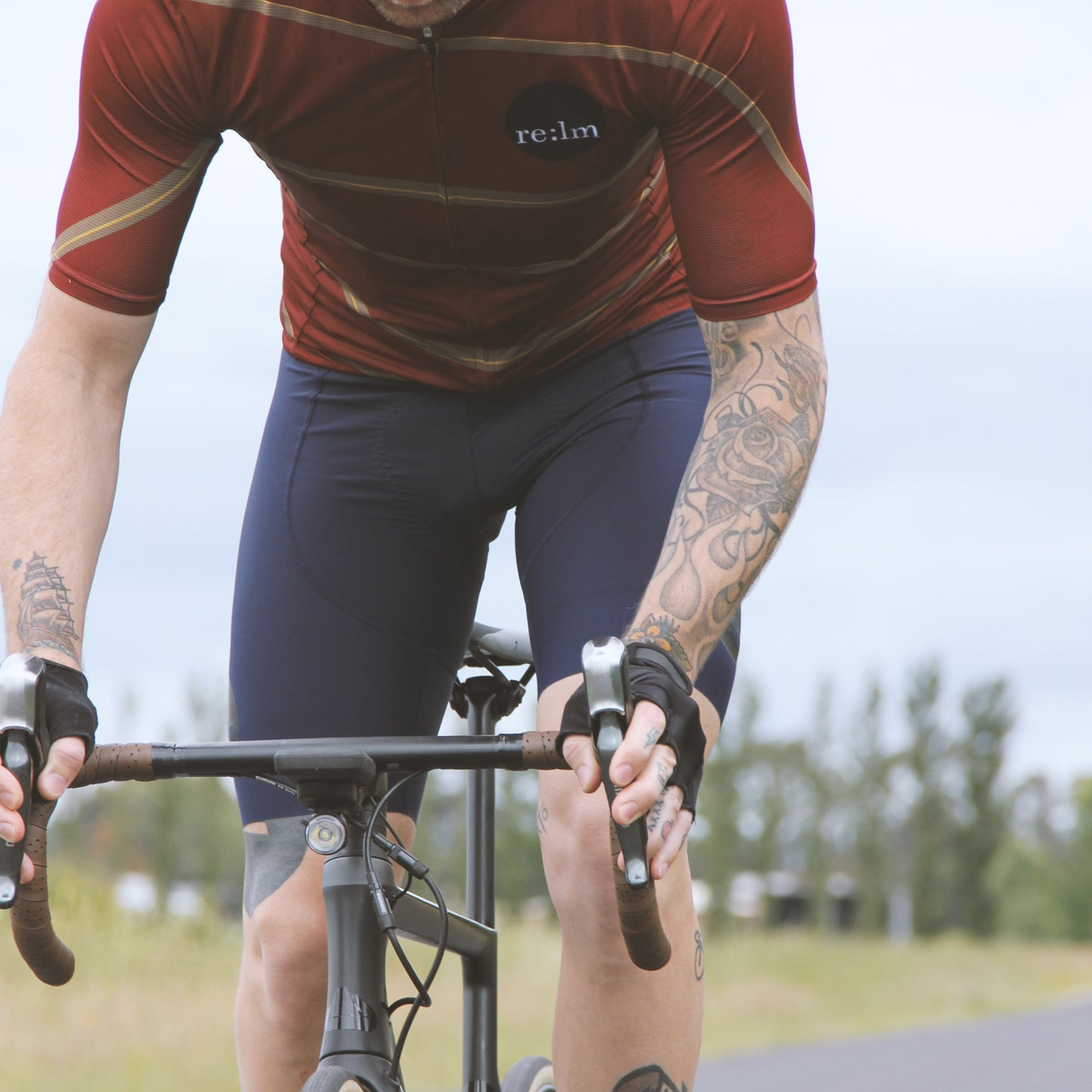 Man riding bike wearing Relm Cycling jersey in offset